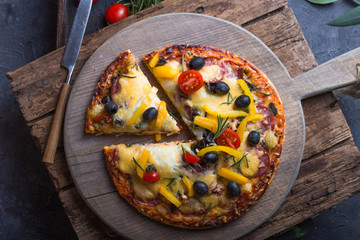 Italian traditional cuisine, pizza, food background. Fresh baked pizza with prosciutto and arugula on wooden table, copy space. Restaurant menu photo, pizzeria, food recipe, pizza delivery concept