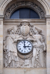 Two muses support the clock, topped by the coat of arms of Cardinal Richelieu, facade of the Saint Ursule chapel of the Sorbonne in Paris, France