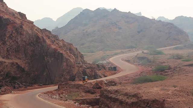 Road with the colored desert mountains of Hormuz island. Iran.