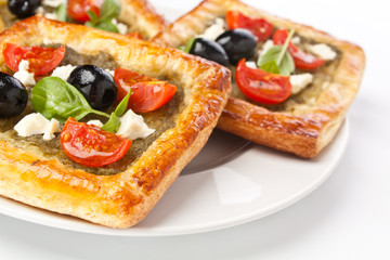 Mediterranean puff pastry with pesto, cherry tomatoes, olives and feta cheese
