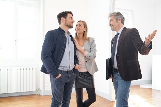 Couple with real-estate agent visiting light contemporary house