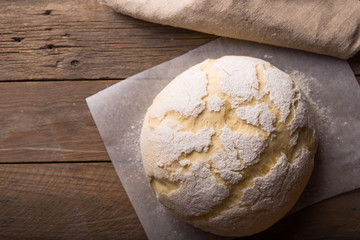 Dough and ingredients for it - eggs flour yeast on brown wooden background. Selective focus.