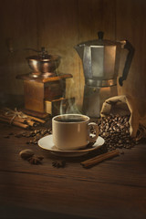Coffee cup and coffee beans on a wooden table and dark background