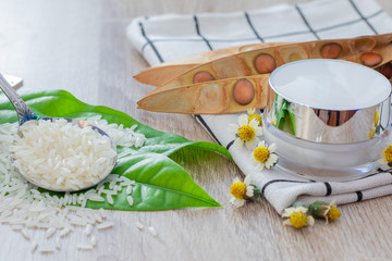 White lotion jar Lotion jars with seeds and flowers around The lotion bottle is placed on the wood.