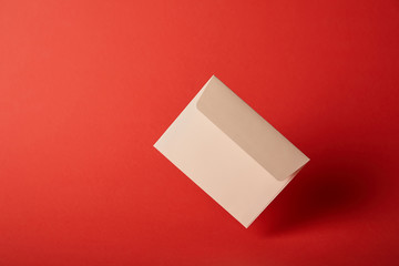 beige, blank and empty envelope on colorful red background with copy space