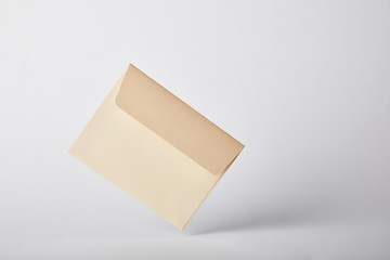 beige and empty envelope on grey background with copy space