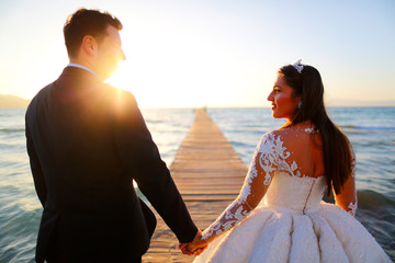 Wedding couple, bride, groom walking and posing on pier