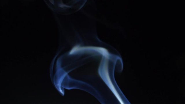 blue smoke rises on a black background