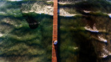 Bride and groom walking on dock at sea