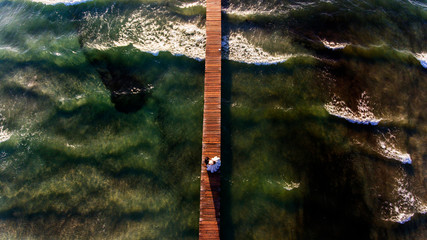 Bride and groom walking on dock at sea