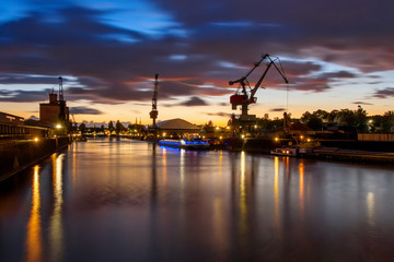 Fototapeta na wymiar Industriehafen bei wunderschönem Sonnenuntergang mit roten Wolken und Platz für Schrift
