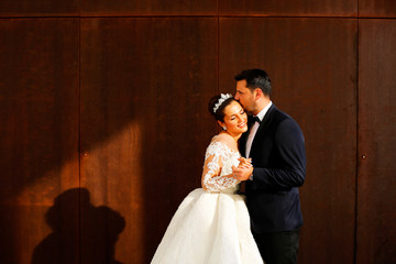 Beautiful wedding couple posing in sun