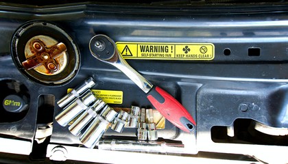 Tools on car engine bay. Tools with engine bay on background. Tools with yellow warning on background.