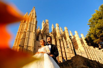 Beautiful wedding couple enjoying sun near old cathedral