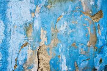 Blaue Wand mit Rissen und Abblätterungen