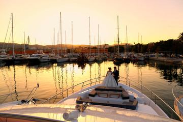 Wedding couple posing on boat at sunset