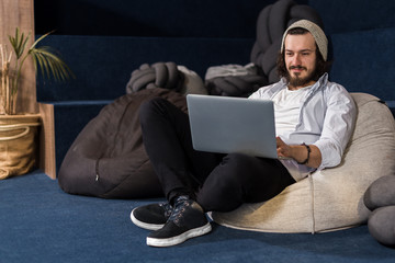 Caucasian man working on a laptop in casual workplace environment