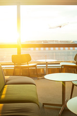 Airport terminal background. Modern international airport during sunset. Airplane departure at sunset, through the gate airport cafe window