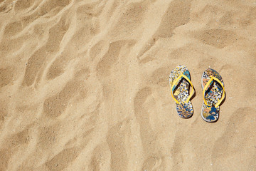 Closeup Beach Sandals Flip Flops or Tongs Sandy Beach Background Copyspace. Summer Concept. Horizontal. No body photo