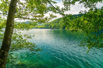 wonderful lake landscape with a boat servicing visitors crossing the lake of Plitvice in National Park, UNESCO World Heritage site
