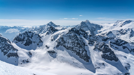 Switzerland, panorama view from Titlis mountain on Alps and mountains above white clouds