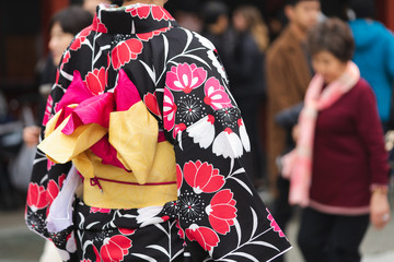 Young girl wearing Japanese kimono standing in front of Sensoji Temple in Tokyo, Japan. Kimono is a Japanese traditional garment. The word 