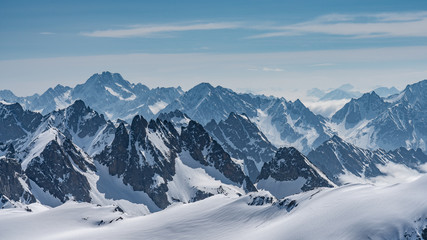 Fototapeta premium Switzerland, panorama view from Titlis mountain on Alps and mountains above white clouds