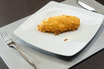 Chicken breast breaded on a plate on the table