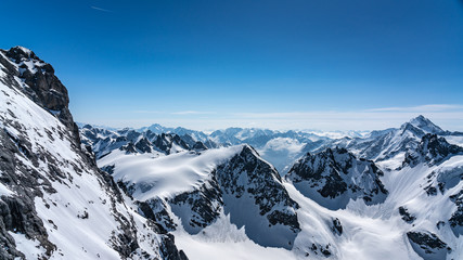 Obraz premium Switzerland, panorama view from Titlis mountain on Alps and mountains above white clouds