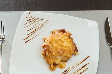 Meat in batter on a white plate on the table