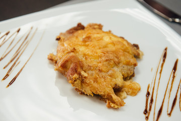 Meat in batter on a white plate on the table
