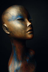 Closeup studio shot of colored woman mannequin with stylish decoration, dark background