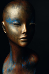 Closeup studio shot of colored woman mannequin with stylish decoration, dark background