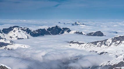 Switzerland, panorama view from Titlis mountain on Alps and mountains above white clouds