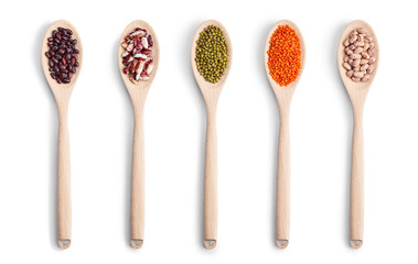 A set of wooden spoons with different beans isolated in white background. Top view.