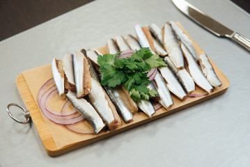 fresh sprat with greens on a cutting board on the table