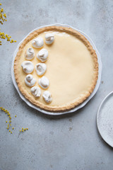 Traditional lemon tart with curd filling decorated with meringues.