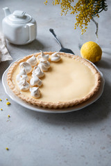 Traditional lemon tart with curd filling decorated with meringues.