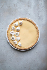 Traditional lemon tart with curd filling decorated with meringues.