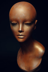 Closeup studio shot of colored woman mannequin with stylish decoration, dark background