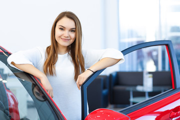 Attractive young woman at the car dealership