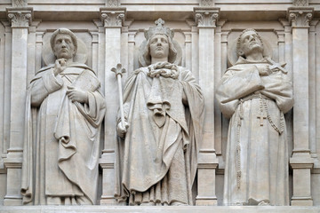 Fototapeta na wymiar Saints Dominic, Louis and Francis of Assisi, statue on the facade of Saint Augustine church in Paris, France 