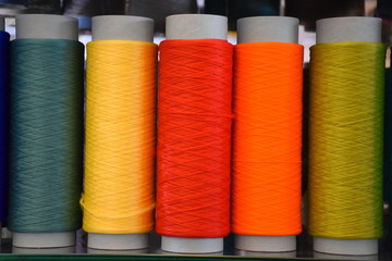 Five bobbins with polypropylene thread, fabric and textile industry.Large colorful technical thread...