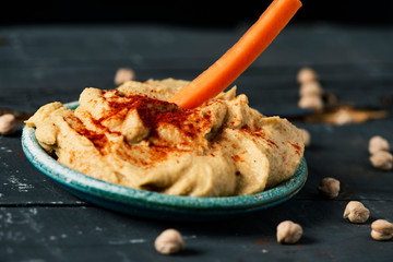 dipping carrot in a homemade hummus
