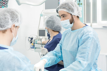 Naklejka na ściany i meble Team of surgeons performing surgery in operation room