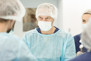 Confident male surgeon performing operating at the hospital