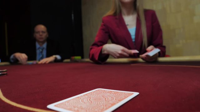 Casino gamble: Dealer deals the cards. Players bet. Cards close-up. Slow motion.