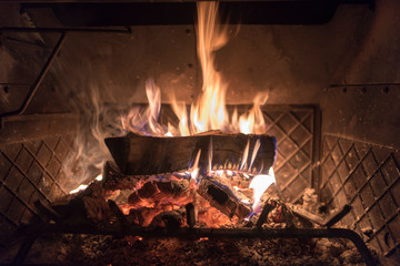 a streak of fire emitting from a single log inside of a wood burning stove