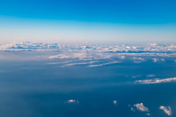Fototapeta na wymiar 高空より雲間に海や地上が覗く風景が美しい