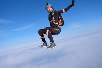 Obraz premium Skydiving. Pretty girl is sitting above white clouds.